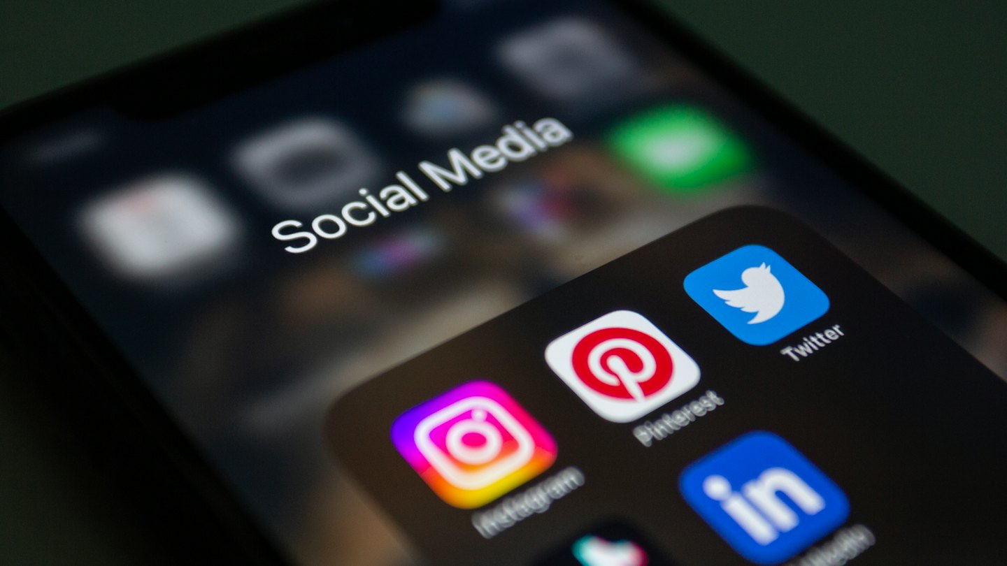 Smartphone screen shows social media app icons in a folder.