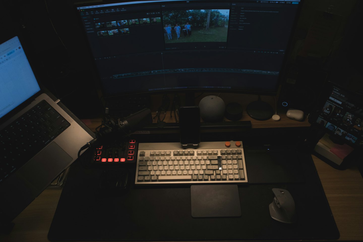 A computer workstation with multiple monitors displaying video editing software.